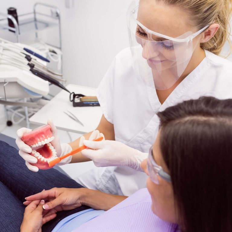 dentist-showing-model-teeth-female-patient (1)